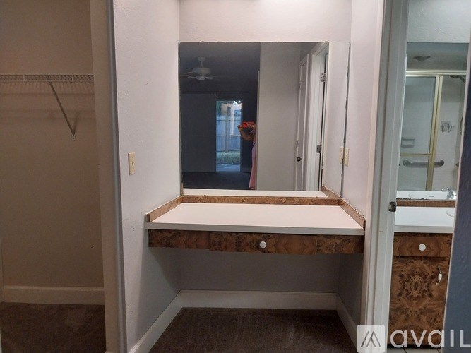 A bathroom with a mirror and a wooden vanity.