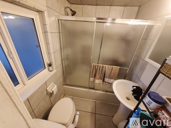 A bathroom with a toilet, sink, and shower.
