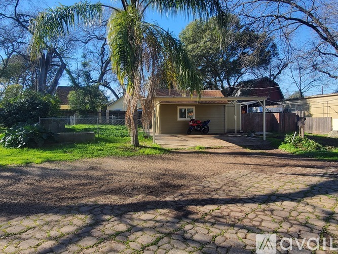 A house with a driveway and a tree in front of it.
