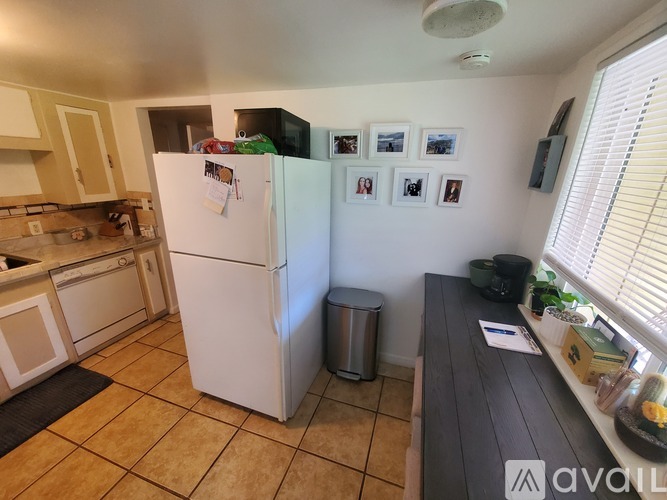 A kitchen with a white fridge and a black counter.