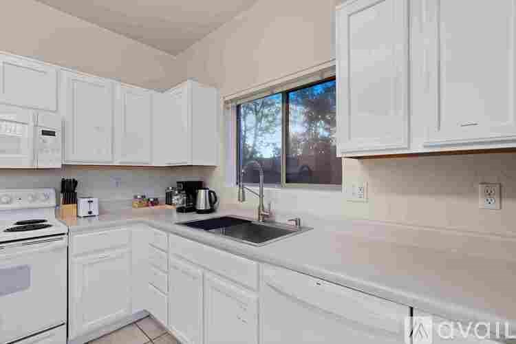 A kitchen with white cabinets and appliances.