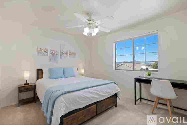 A bedroom with a bed, desk, and chair.