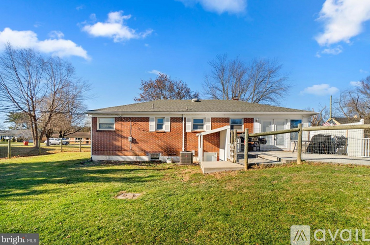 A red brick house with a white door and windows is for sale.