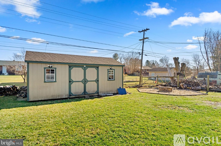 A small building with a green door and a window is surrounded by a grassy area.