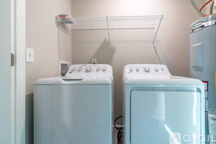 Two white washing machines in a small laundry room.