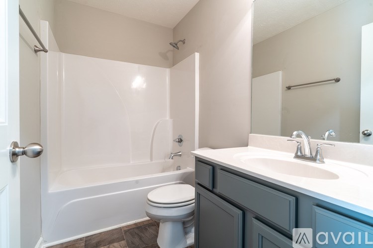 A bathroom with a toilet, sink, and bathtub.
