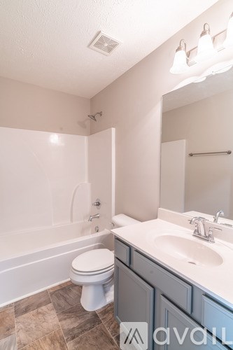 A bathroom with a toilet, sink, and tub.