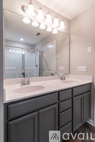 A bathroom with a double sink and a mirror above it.