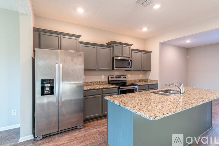 A kitchen with a granite countertop and stainless steel appliances.