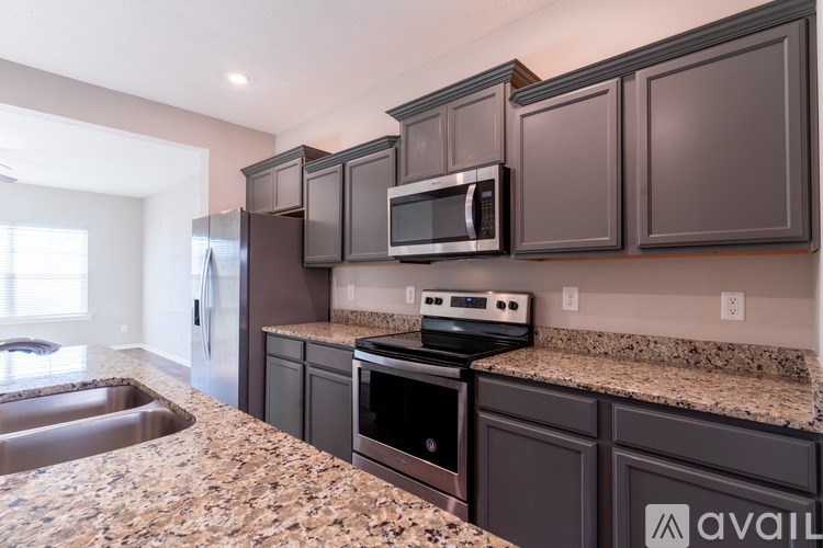 A kitchen with granite countertops and dark brown cabinets.