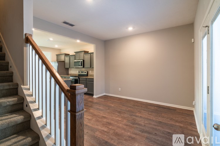 A spacious room with a staircase leading to the upper level.