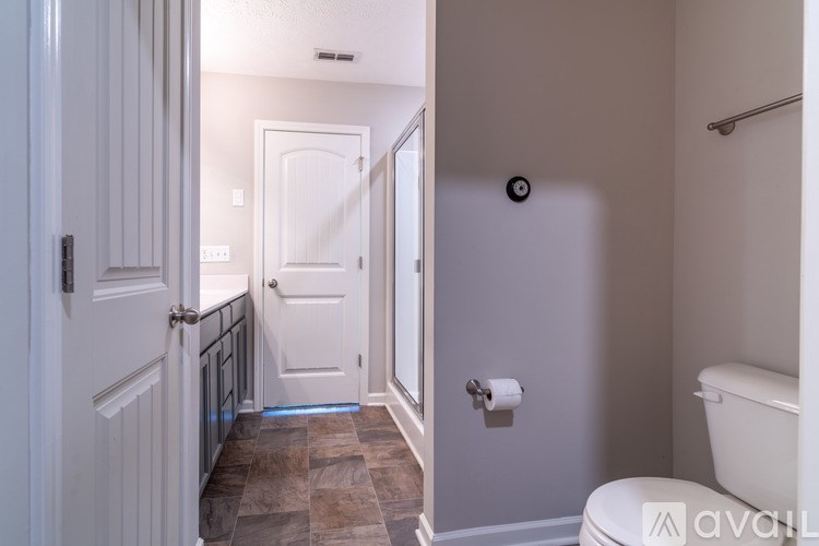 A bathroom with a toilet, sink, and a door.