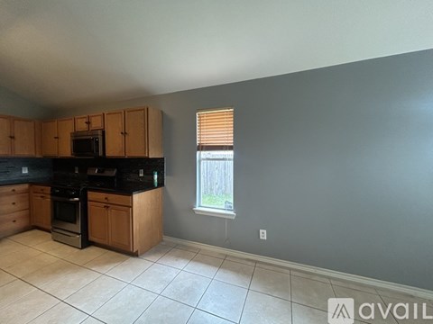 A kitchen with wooden cabinets and black countertops.