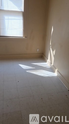 A room with a window and sunlight coming through.