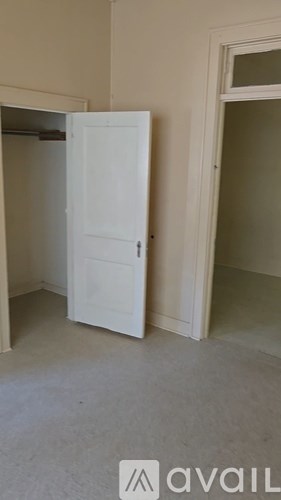 A white door is in a room with a carpeted floor.