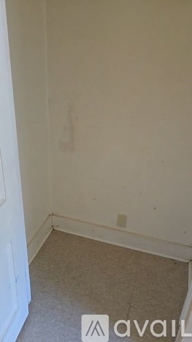 A room with a carpeted floor and a white door.