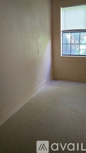 A room with a window and a wall with a hole in it.