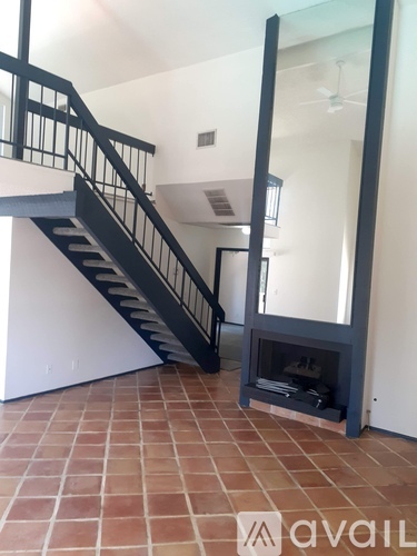 A black metal staircase with a glass balustrade.