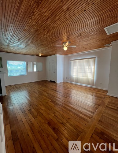 A room with wooden floors and a ceiling fan.