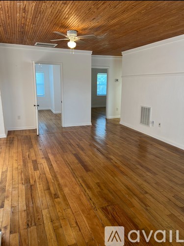 A room with wooden floors and a ceiling fan.
