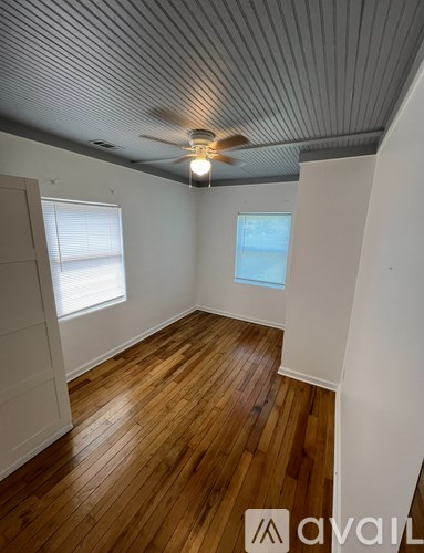 A room with wooden floors and a ceiling fan.