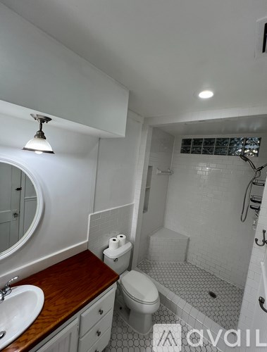 A bathroom with a toilet, sink, and mirror.