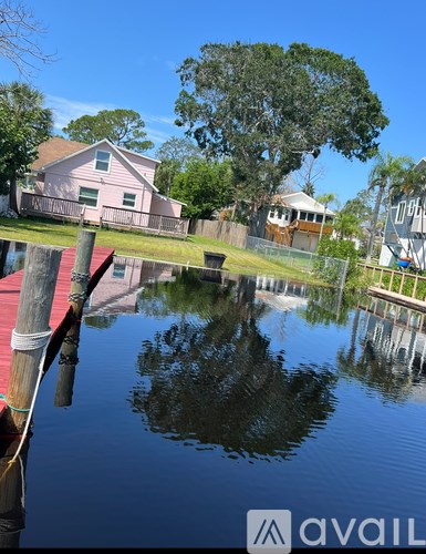A house is reflected in the still water of a pond.