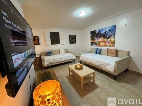 A living room with two couches, a coffee table, and a television displaying Netflix.