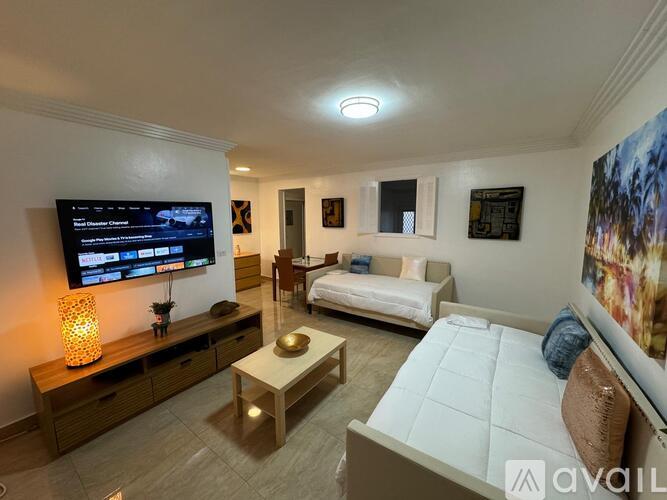 A living room with a flat screen TV mounted on the wall.