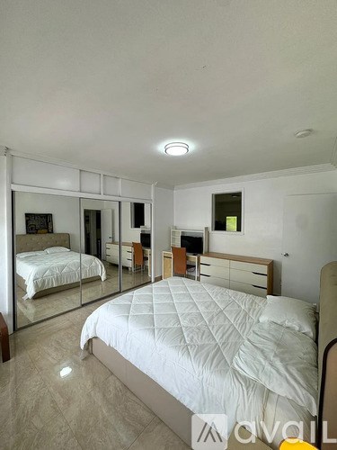 A bedroom with a large bed and a mirrored closet.