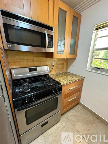 A kitchen with wooden cabinets and a stainless steel oven.