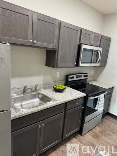 A kitchen with dark wood cabinets and stainless steel appliances.