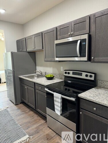 A kitchen with a black fridge, black oven, and black microwave.