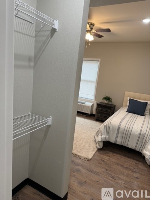 A white closet with a bedroom in the background.