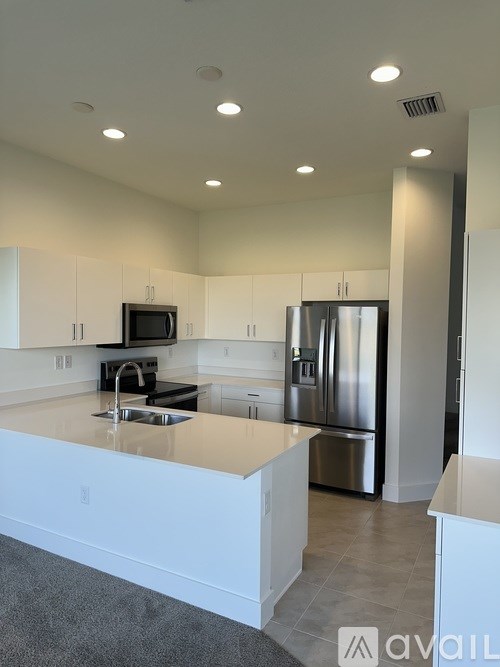 A modern kitchen with stainless steel appliances and white cabinets.