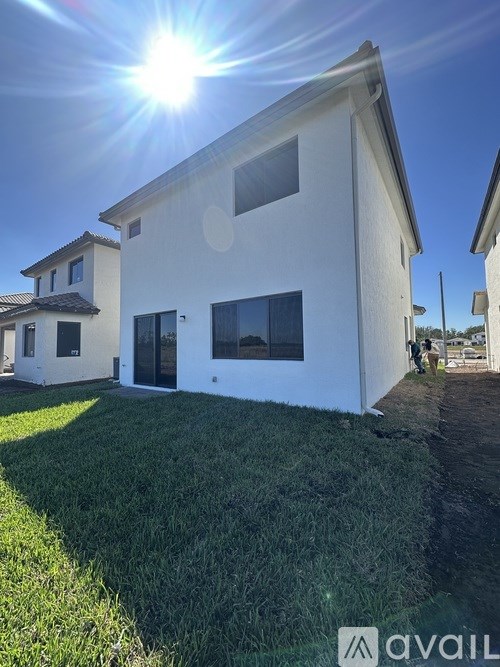 A white house with a sun shining in the background.