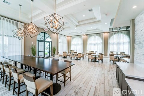 A modern dining room with a long table and chairs.
