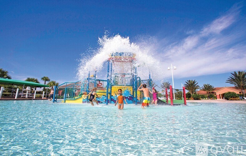 People are playing in a water park with a large splash from a water slide.