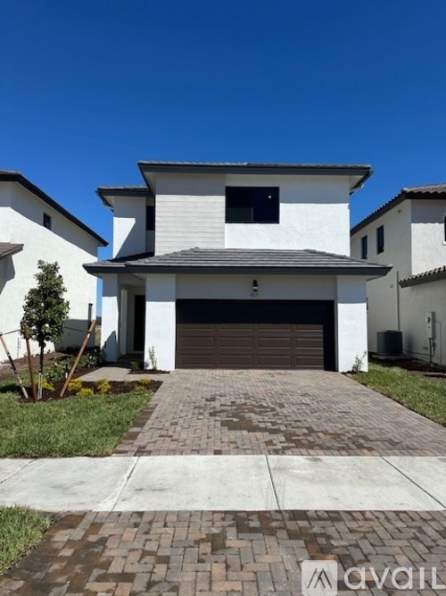A white house with a brown garage door is shown.
