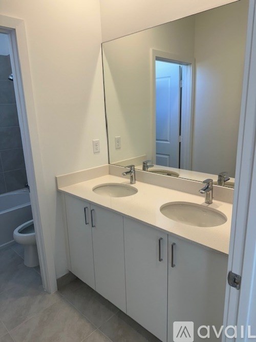 A bathroom with a white countertop and a large mirror.