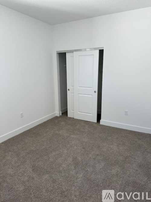A room with a carpeted floor and a white door.