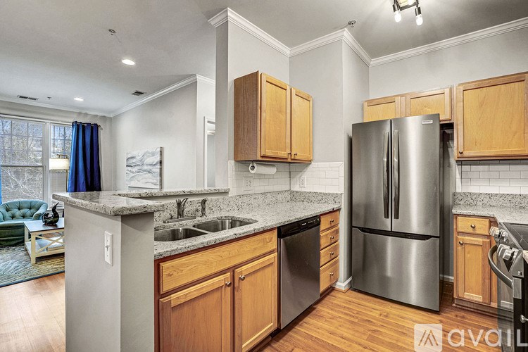 A kitchen with wooden cabinets and a stainless steel refrigerator.