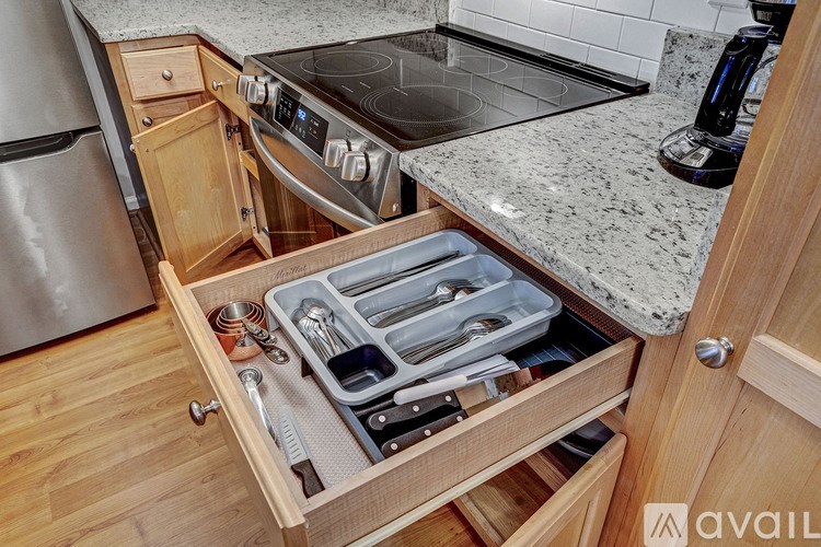 A kitchen drawer with utensils and a knife block.
