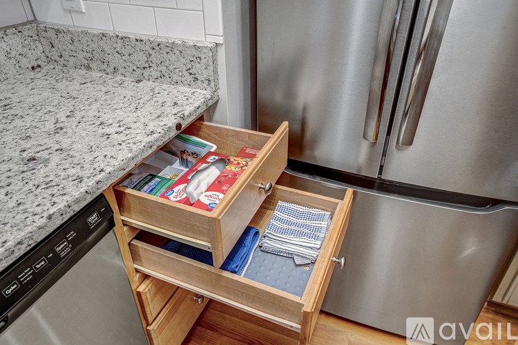 A kitchen drawer with a container of paper towels and a blue and white striped cloth.