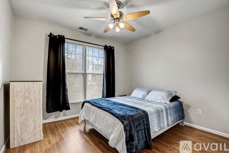 A bedroom with a bed, dresser, and window.