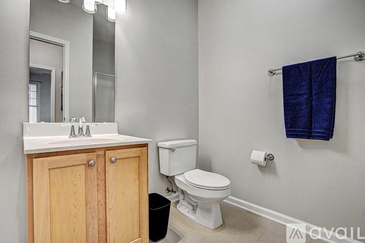 A bathroom with a toilet, sink, and mirror.