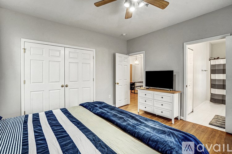 A bedroom with a bed, dresser, and television.