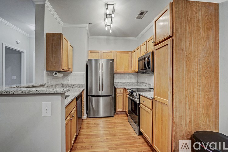 A kitchen with wooden cabinets and a stainless steel refrigerator.
