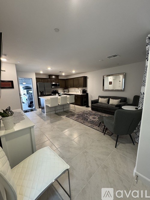 A modern living room with a kitchen in the background.