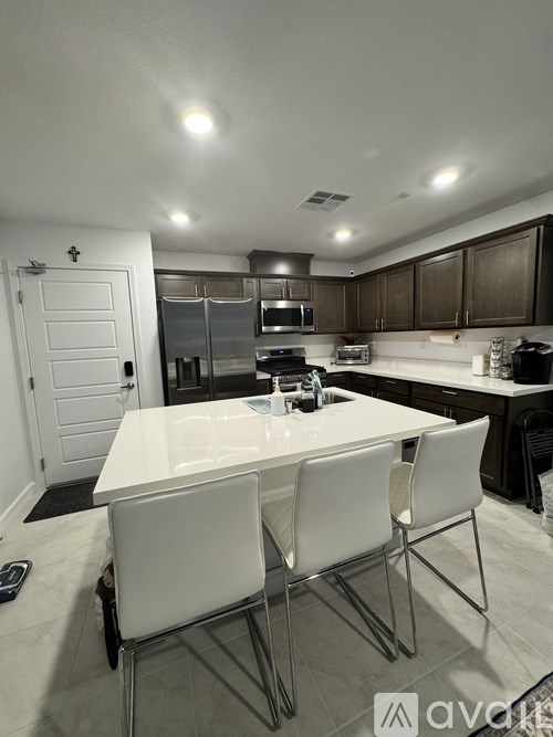 A kitchen with a white table and chairs.